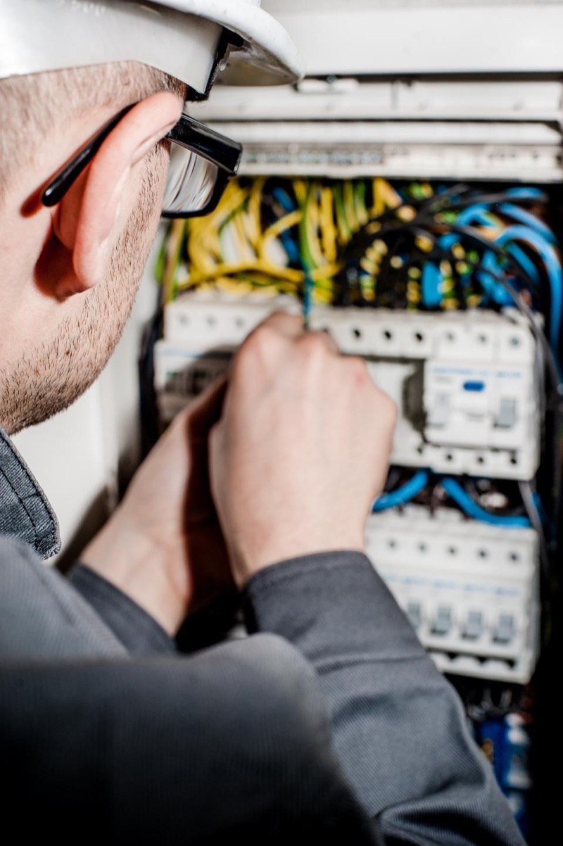 Electrician connecting wires inside a breaker panel